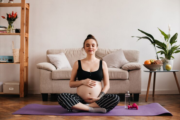 cheerful brunette pregnant woman enjoys music white wireless headphones gently touches belly cheerful tanned girl black pants top meditating purple carpet