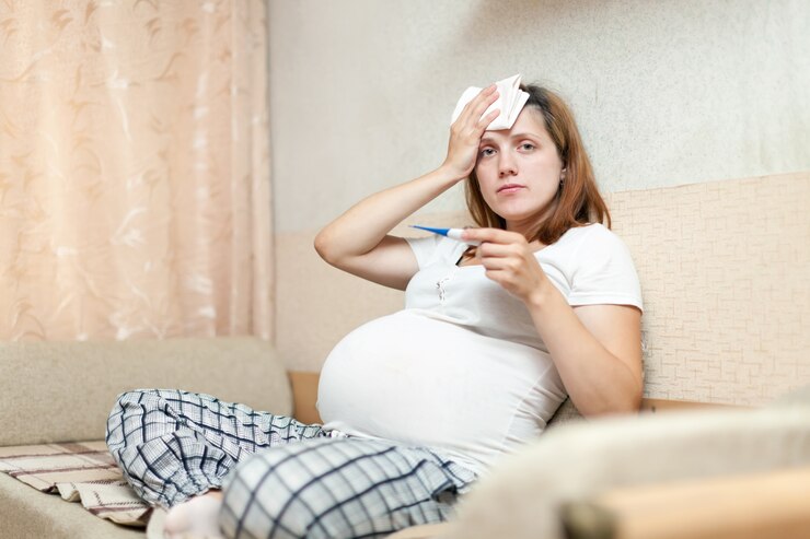 pregnant woman with thermometer living room