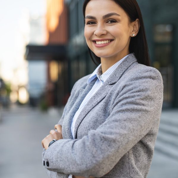 smiley businesswoman posing city with arms crossed